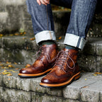 Botines de cuero café Kalver Andino combinados con jeans enrollados en un entorno urbano